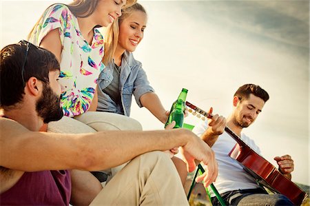 play with food - Young people listening to guitarist at rooftop party Stock Photo - Premium Royalty-Free, Code: 6115-08101142