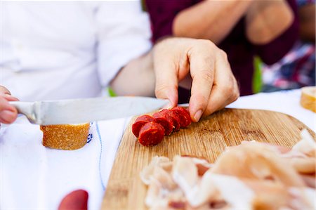 people in garden - Cutting a sausage, Munich, Bavaria, Germany Stock Photo - Premium Royalty-Free, Code: 6115-08101367
