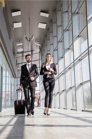 Business partners walking in lobby at airport Stock Photo - Premium Royalty-Free, Code: 6115-08104948