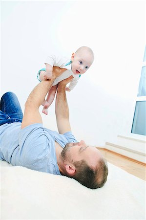 simsearch:6115-07539732,k - Father relaxing with baby boy Stock Photo - Premium Royalty-Free, Code: 6115-08104921