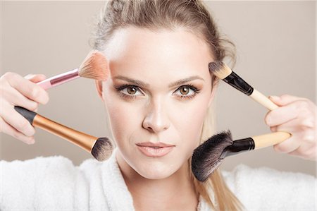 simsearch:693-06022101,k - Young woman holding makeup brushes Stock Photo - Premium Royalty-Free, Code: 6115-08105085