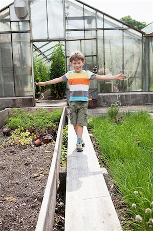 simsearch:6115-07539732,k - Boy playing in front of greenhouse Stock Photo - Premium Royalty-Free, Code: 6115-08239184