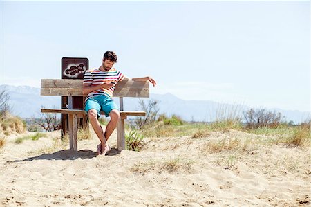 simsearch:6115-06733060,k - Young man using handy on beach Foto de stock - Sin royalties Premium, Código: 6115-08239245