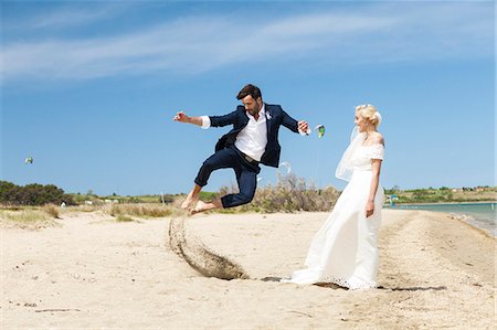 Bride and bridegroom on beach having fun Stock Photo - Premium Royalty-Free, Code: 6115-08239427