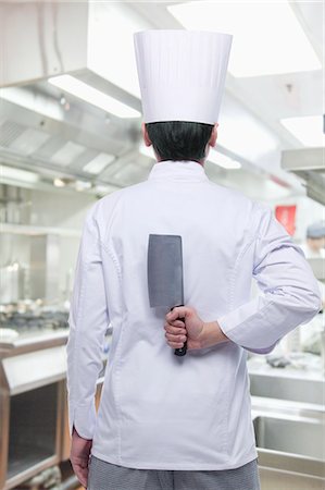 Rear View of Chef with Knife Behind his Back Stock Photo - Premium Royalty-Free, Code: 6116-06938540