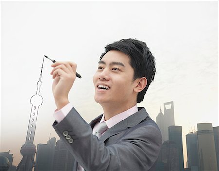 Young Businessman drawing Shanghai skyline Stock Photo - Premium Royalty-Free, Code: 6116-06938507