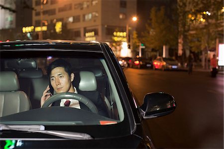 driving in asia - Businessman With Cell Phone In Car Photographie de stock - Premium Libres de Droits, Code: 6116-06938914