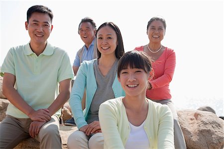 Portrait of smiling multigenerational family sitting on the rocks outdoors, China Stock Photo - Premium Royalty-Free, Code: 6116-06939008