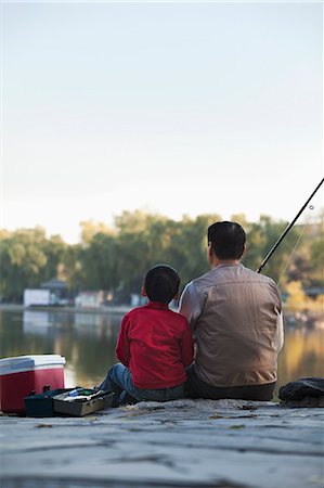 Grandfather and grandson sitting and fishing at a lake Photographie de stock - Premium Libres de Droits, Code: 6116-06939394