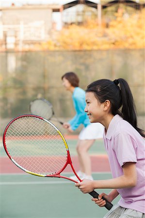 preteen asian girls - Mother and daughter playing tennis Stock Photo - Premium Royalty-Free, Code: 6116-06939316