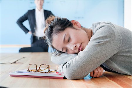 Young businesswoman sleeping during meeting, disappointed Boss looking at her Stock Photo - Premium Royalty-Free, Code: 6116-06939493