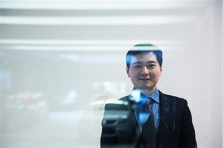 Businessman looking thorough window in parking garage Foto de stock - Sin royalties Premium, Código: 6116-06939418