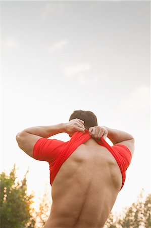 Muscular Man Taking Off His Shirt Stock Photo - Premium Royalty-Free, Code: 6116-07084587