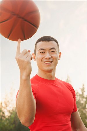 Athletic Man Spinning Basketball and Looking at Camera Stock Photo - Premium Royalty-Free, Code: 6116-07084586