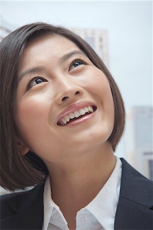 simsearch:6116-07084811,k - Portrait of Smiling Young Businesswoman, Looking up Stock Photo - Premium Royalty-Free, Code: 6116-07084850