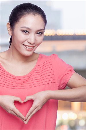 Young Woman Making Heart Sign with Hands Stock Photo - Premium Royalty-Free, Code: 6116-07084824