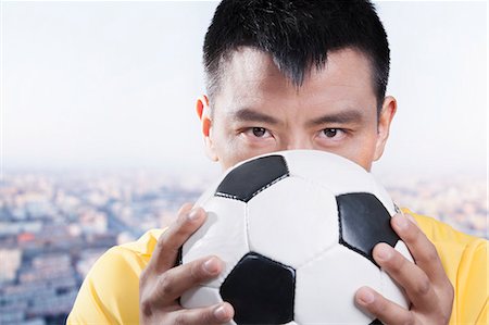 footballeur - Footballer holding ball against his face Stock Photo - Premium Royalty-Free, Code: 6116-07085156