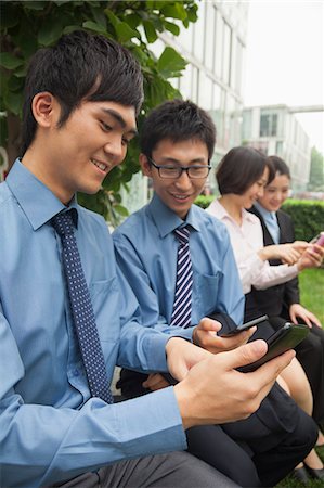 simsearch:6116-07084811,k - Young business people checking their cell phones Stock Photo - Premium Royalty-Free, Code: 6116-07085569
