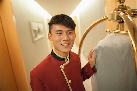 Bellhop smiling, portrait Stock Photo - Premium Royalty-Free, Code: 6116-07085524