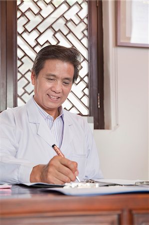 simsearch:6116-07086677,k - Doctor Writing at His Desk Stock Photo - Premium Royalty-Free, Code: 6116-07085533