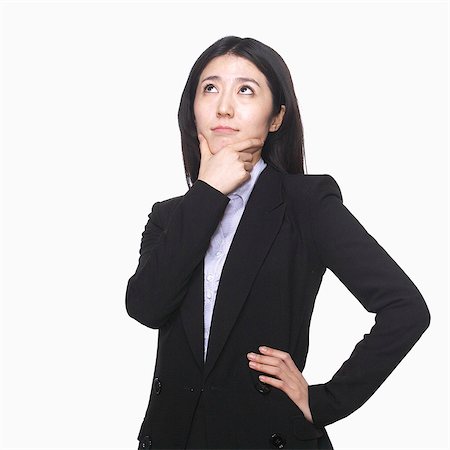 Businesswoman with hand on chin thinking Stock Photo - Premium Royalty-Free, Code: 6116-07086339