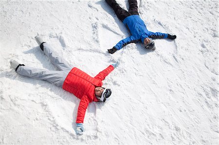 fun winter people - Couple Lying On Snow Making Snow Angel Stock Photo - Premium Royalty-Free, Code: 6116-07086609