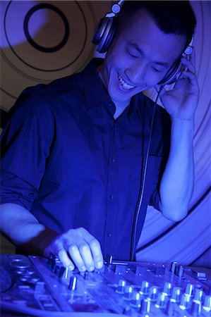 simsearch:6116-07236256,k - A portrait of a young male DJ playing music in a nightclub Stock Photo - Premium Royalty-Free, Code: 6116-07235653