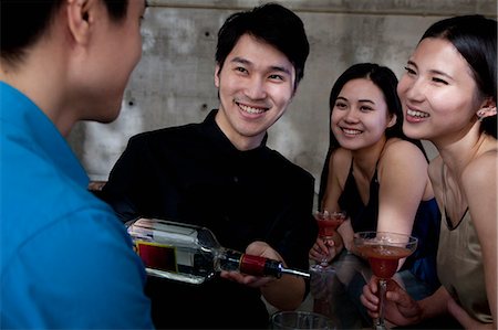 simsearch:6116-07236256,k - A young men bartender serving drinks to group of friends Stock Photo - Premium Royalty-Free, Code: 6116-07235665