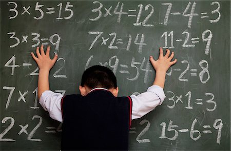 equation - Schoolboy in front of blackboard with hands on chalkboard Photographie de stock - Premium Libres de Droits, Code: 6116-07235690