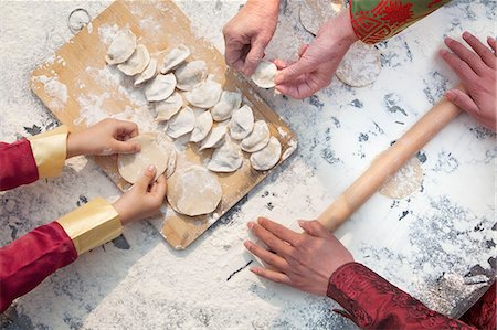 preparing food - Three generation of women making dumplings, hands only Foto de stock - Sin royalties Premium, Código: 6116-07235722