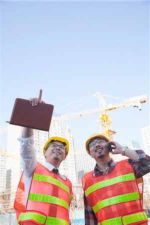 Two architects looking and pointing at construction site Stock Photo - Premium Royalty-Free, Code: 6116-07235739