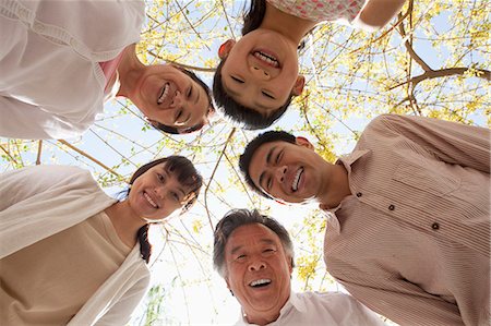 simsearch:6116-06939008,k - Happy smiling family in a circle looking down in a park in the springtime Stock Photo - Premium Royalty-Free, Code: 6116-07235876