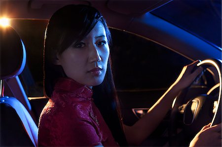 driving in asia - Portrait of young, beautiful woman in traditional clothing driving at night in Beijing Stock Photo - Premium Royalty-Free, Code: 6116-07235829