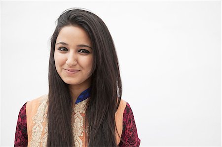 pakistan - Portrait of smiling young woman wearing traditional clothing from Pakistan, studio shot Stock Photo - Premium Royalty-Free, Code: 6116-07235999