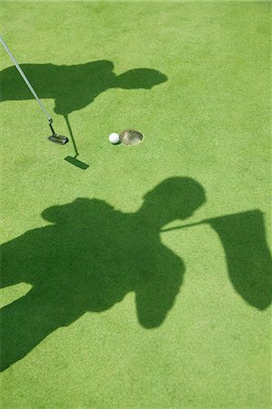 putt - Shadows of two golfers hitting the ball on the golf course, ball in the hole Stock Photo - Premium Royalty-Free, Code: 6116-07236031