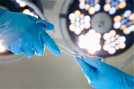 surgery not animal not dog - Close-up of gloved hands passing the surgical scissors, operating room, hospital Stock Photo - Premium Royalty-Free, Code: 6116-07236153