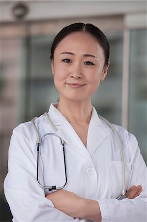 professional occupation - Portrait of female doctor with arms crossed outside of the hospital Stock Photo - Premium Royalty-Free, Code: 6116-07236173