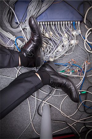 plugging in - Businessman's feet on the ground surrounded by computer cables Stock Photo - Premium Royalty-Free, Code: 6116-07236260