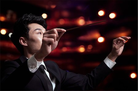 performance hall interior - Young conductor with baton raised at a performance Stock Photo - Premium Royalty-Free, Code: 6116-07236206