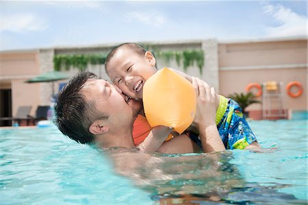 simsearch:6116-07236315,k - Portrait of father embracing his smiling son in the pool Foto de stock - Sin royalties Premium, Código: 6116-07236395