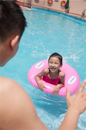 simsearch:6116-07236315,k - Little girl with a pink tube and her father swimming in the pool Foto de stock - Sin royalties Premium, Código: 6116-07236306