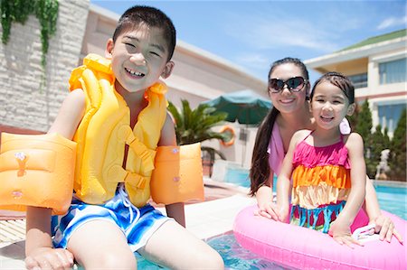 simsearch:6116-07236315,k - Family portrait, mother, daughter, and son, by the pool with pool toys Foto de stock - Sin royalties Premium, Código: 6116-07236311