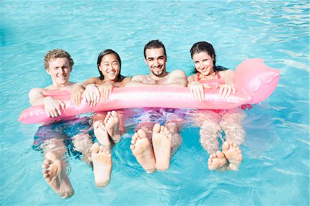 simsearch:6116-07236315,k - Portrait of four friends in the pool with an inflatable raft Foto de stock - Sin royalties Premium, Código: 6116-07236330