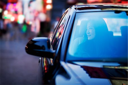 driving in asia - Serene woman looking through car window at the city nightlife Photographie de stock - Premium Libres de Droits, Code: 6116-07236487