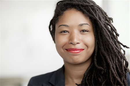 Portrait of smiling businesswoman with dreadlocks, head and shoulders Stock Photo - Premium Royalty-Free, Code: 6116-07236434