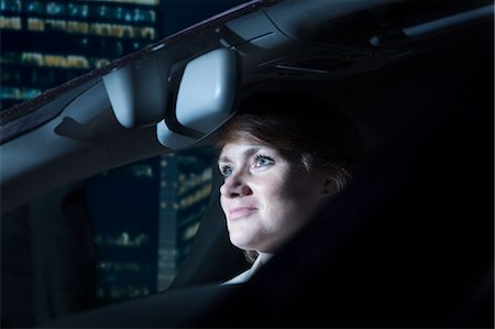 Businesswoman driving at night in the city Stock Photo - Premium Royalty-Free, Code: 6116-07236500