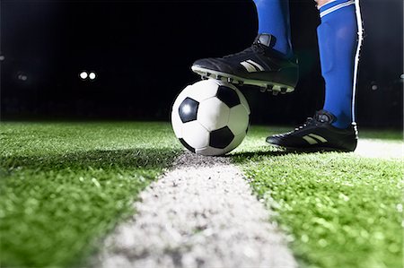 soccer player kicking ball into the goal - Foot on soccer ball Stock Photo - Premium Royalty-Free, Code: 6116-08540018