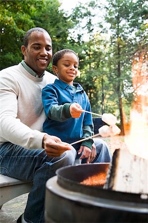Father and son toasting marshmallows Stock Photo - Premium Royalty-Free, Code: 6116-08945555
