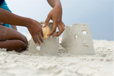 Mother and child putting a shell on a sandcastle Stock Photo - Premium Royalty-Free, Code: 6116-08915813