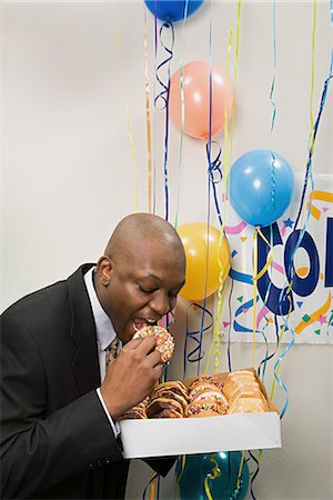 stealing (not forced entry) - Businessman secretly eating doughnuts Stock Photo - Premium Royalty-Free, Code: 6116-09013693